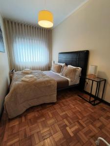 a bedroom with a large bed and a wooden floor at Art Gallery Apartment in Porto