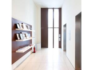 a hallway with white tile flooring and bookshelves at Hotel day by day - Vacation STAY 93900 in Hamamatsu