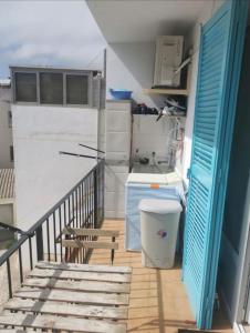 a kitchen with a staircase with a blue door and a trash can at El Niu de Sant Antoni de Calonge in Calonge