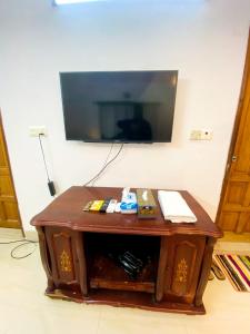 uma mesa de madeira com uma televisão na parede em Cozy private Ac Attached bath Room- Gulshan 1 em Daca