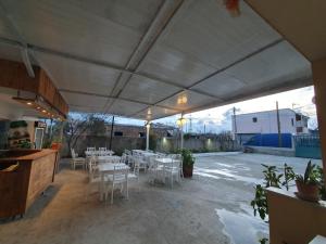 une terrasse avec des tables et des chaises blanches sous une tente dans l'établissement L&G Hotel, à Vlorë