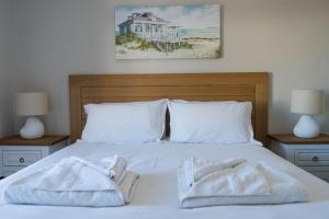 Una cama blanca con dos toallas encima. en NEW! A haven by the water en Wootton
