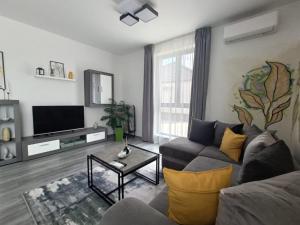 a living room with a couch and a tv at Apartament Maia Baile Felix in Baile Felix