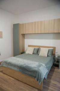 una camera con un grande letto con testiera in legno di Casa Boschi in centro città a Pescara