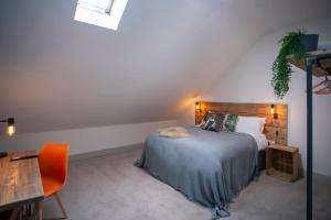 a bedroom with a bed and a table and a chair at higgihaus Cabot Mews #40 Prime Central Location in Bristol