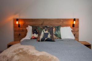 a bed with a wooden headboard and pillows on it at higgihaus Cabot Mews #40 Prime Central Location in Bristol