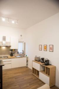 una cucina con armadietti bianchi e pavimenti in legno di Casa Boschi in centro città a Pescara