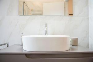 un lavandino bianco in un bagno con specchio di Casa Boschi in centro città a Pescara