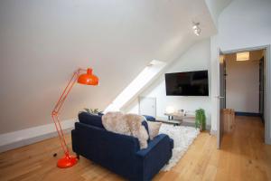 sala de estar con sofá azul y lámpara en higgihaus Cabot Mews #40 Sunday - Friday Central Location, en Bristol