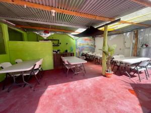 a restaurant with tables and chairs in a room with green walls at Hotel Posada Gutierrez in Panajachel