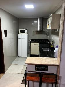 a small kitchen with a stove and a refrigerator at Linda Casa com Estacionamento in Juiz de Fora