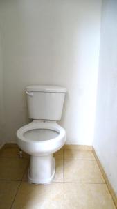 a bathroom with a white toilet in a room at Hostal Madrid in Tapachula