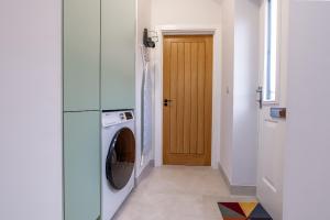 a laundry room with a washer and dryer next to a door at Stag Suite: Elegant Comfort in Bristol