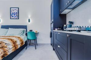a bedroom with blue cabinets and a bed and a sink at Stag Suite: Elegant Comfort in Bristol