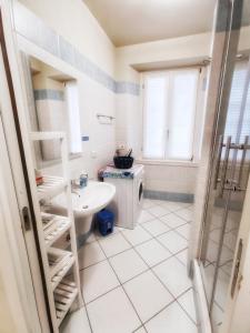 een badkamer met een wastafel en een wasmachine bij CASA LISANDER in Lecco