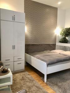 ブダペストにあるDiamond Apartman Near to Basilicaのベッドルーム(白いベッド1台、白いキャビネット付)