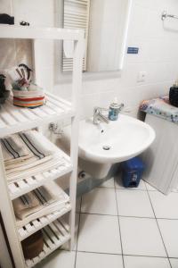 bagno bianco con lavandino e specchio di CASA LISANDER a Lecco