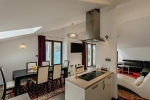 a kitchen and living room with a table and a couch at Apartments Joy in Herceg-Novi