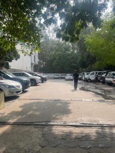 eine Person, die mit Autos einen Parkplatz entlang läuft in der Unterkunft 3BHK Duplex Service Apartment near Riverfront in Ahmedabad