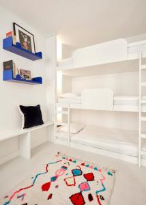 a bedroom with white bunk beds and a rug at Casa Pavão in Lisbon