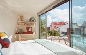 een slaapkamer met een bed en een groot raam bij Casa Pavão in Lissabon