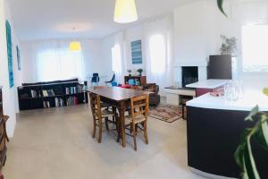 eine Küche und ein Wohnzimmer mit einem Tisch und Stühlen in der Unterkunft Casa Bilum in Sommacampagna