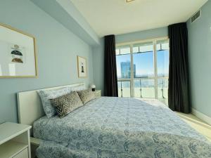 - une chambre avec un lit et une grande fenêtre dans l'établissement Modern Condo Next to CN Tower, à Toronto