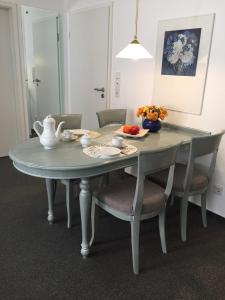 ビンツにあるSilbermöwe im Haus Strelasundの灰色のテーブルと椅子、花瓶