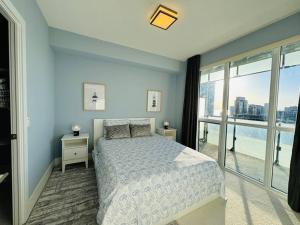 - une chambre avec un lit et une grande fenêtre dans l'établissement Modern Condo Next to CN Tower, à Toronto