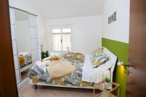 1 dormitorio con 2 camas y espejo en Guest House Fontanesi, en Reggio Emilia