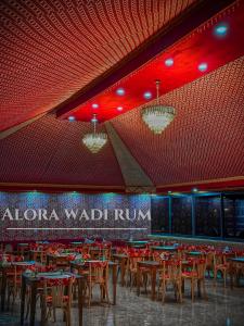a dining hall with tables and chairs and red lights at Alora Wadi Rum Luxury in Wadi Rum