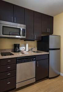 アルバカーキにあるTownePlace Suites by Marriott Albuquerque Northのキッチン(黒いキャビネット、ステンレス製の電化製品付)