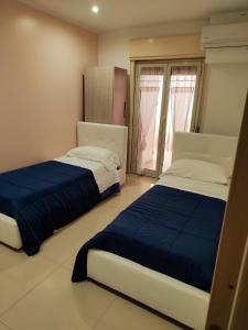 a bedroom with two beds and a window at Trapani love in Trapani