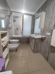 Baño blanco con lavabo y aseo en Trapani love, en Trapani
