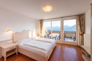 a bedroom with a bed and a balcony at Appartement Tschivon in Schenna