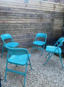 three blue chairs sitting next to a wooden wall at Anfield city break in Liverpool