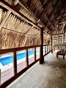 una cabaña de paja con vistas a la piscina en Tiki Hut Hostel, en Palomino