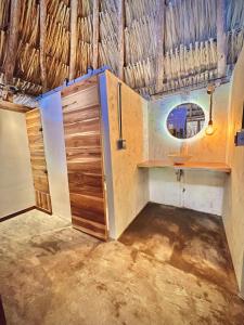 bagno con lavandino e specchio di Tiki Hut Hostel a Palomino