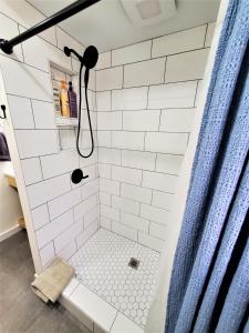 baño con ducha con azulejos blancos de metro en Steps to Beach-Hot Tub-Fireplace-Northern Original, en Traverse City