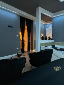 a salon with black chairs and a mirror at Le Suite Piazza Nuova in Foggia