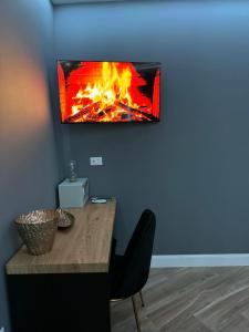 a tv hanging on a wall with a fireplace at Le Suite Piazza Nuova in Foggia