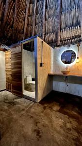ein Bad mit einem Waschbecken und einem Spiegel im Zimmer in der Unterkunft Tiki Hut Hostel in Palomino
