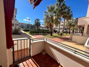 a balcony of a building with palm trees in the background at Apartamentos Arenas Altamar in Alcossebre