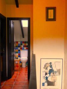 baño con aseo y una foto en la pared en Casa Rural El Pozo Tremeo, en Soña