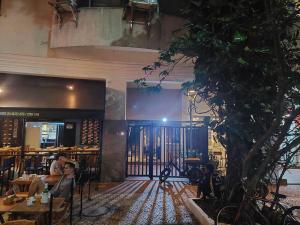 um restaurante com uma árvore e pessoas sentadas às mesas em Quarto e sala no melhor ponto de Ipanema no Rio de Janeiro