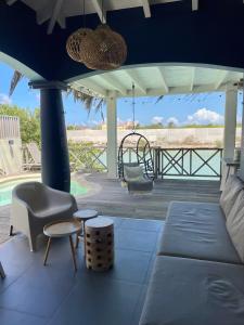 a living room with a couch and chairs on a deck at Villa Bahia Blue in Kralendijk