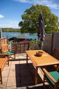 a wooden table and chairs and an umbrella on a patio at Breakfast With A View Free Parking and Water Access in Wallington