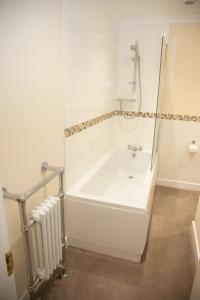 a white bathroom with a tub and a radiator at Breakfast With A View Free Parking and Water Access in Wallington