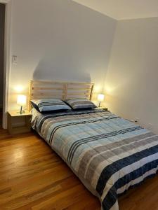 a bedroom with a bed with two lamps on two tables at Bright & Spacious 3-Bed Close to NYC in Jersey City