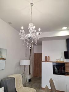 a living room with a chandelier hanging from the ceiling at Apartman DJ in Đakovo